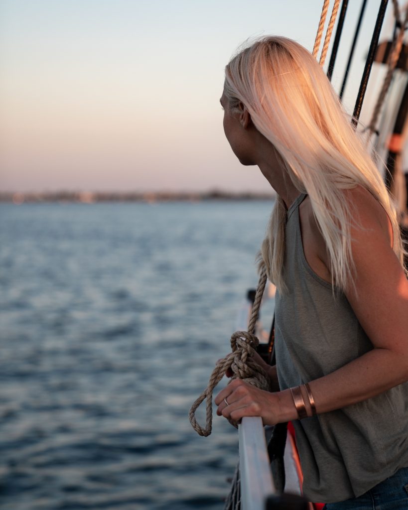 woman looking at the ocean from a sailboat