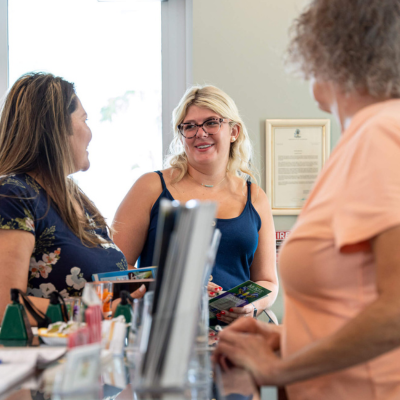 two women talking and a woman trying to join the conversation